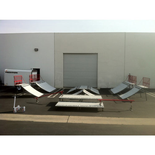 A portable skatepark set up on a trailer, including various skateboarding ramps and rails.